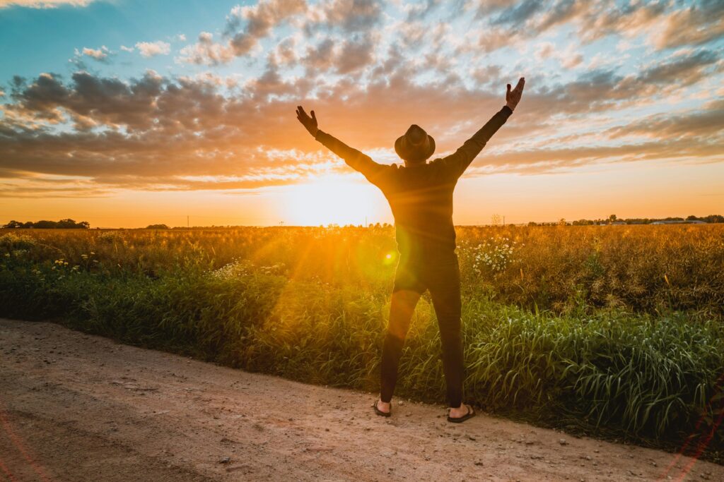 Person with rising sun behind, symbolizing triumph after setbacks.