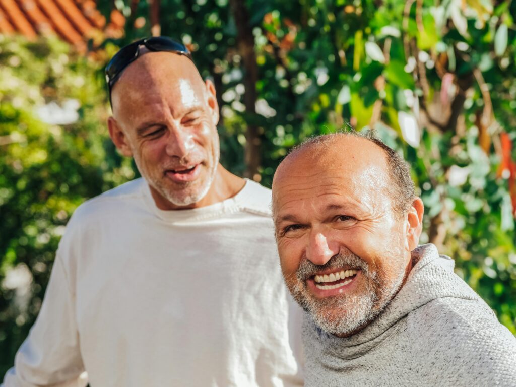 Men over 35 enjoying laughter and connection outdoors to fight social isolation.