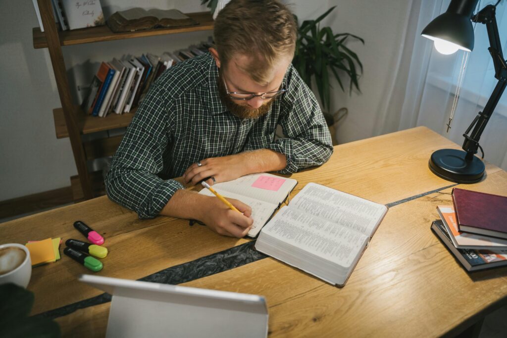 Man writing in a journal during quiet reflection, symbolizing self-inquiry in a men over 35 life overhaul