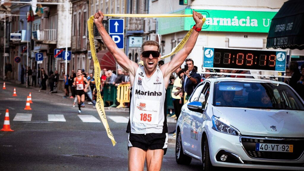 stay the course and finish the race. A man crossing a finish line with arms raised in triumph, symbolizing victory after perseverance.