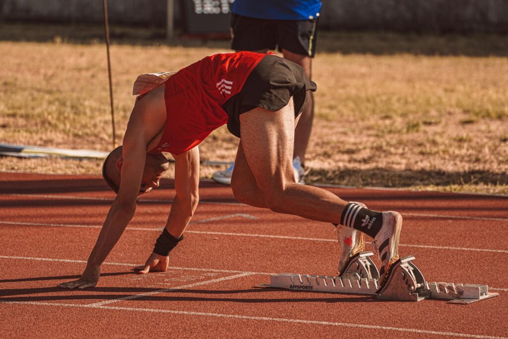 Athlete focused at the starting line showing diligence, focus, and faith in action.