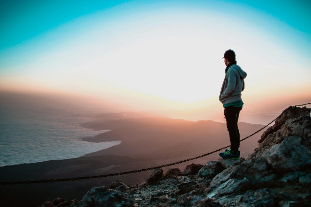 Man standing on a cliff overlooking a horizon, symbolizing reclaiming purpose and life