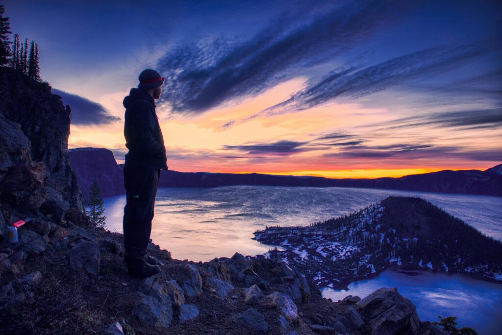 A man over 35 looking at a sunrise, symbolizing personal development, reinvention, and the iron sharpens iron principle.