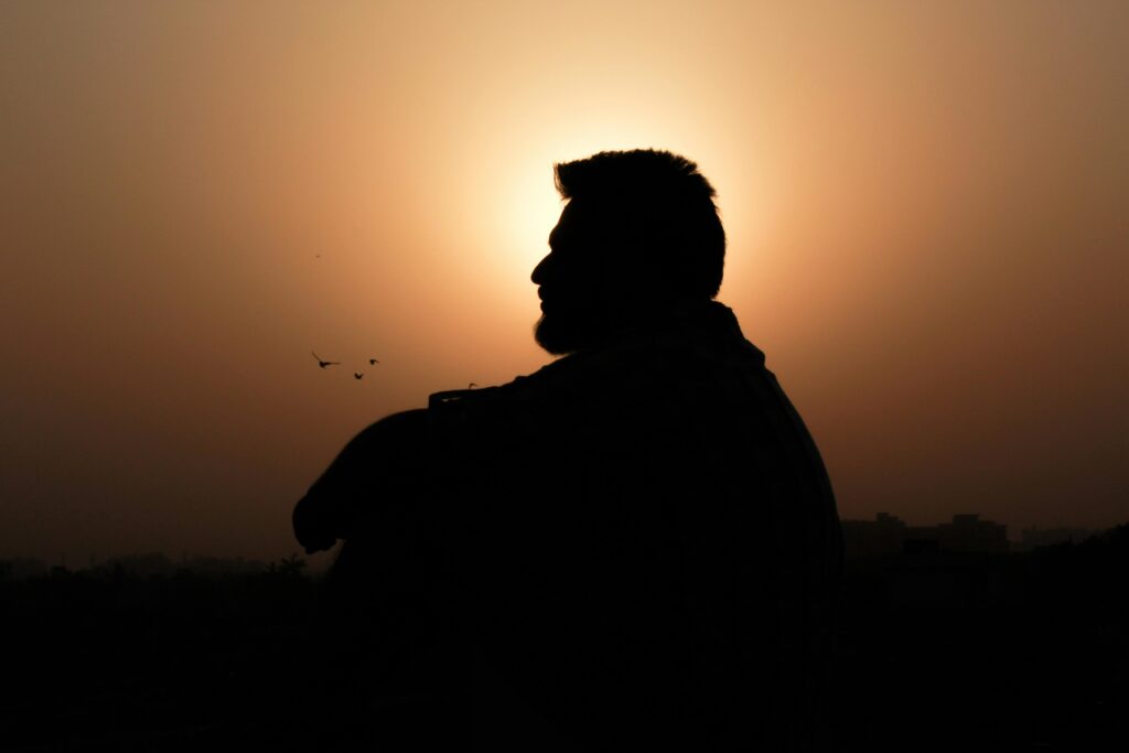Silhouette of a man at the edge of a mountain sunrise, symbolizing conquering fear after 35.