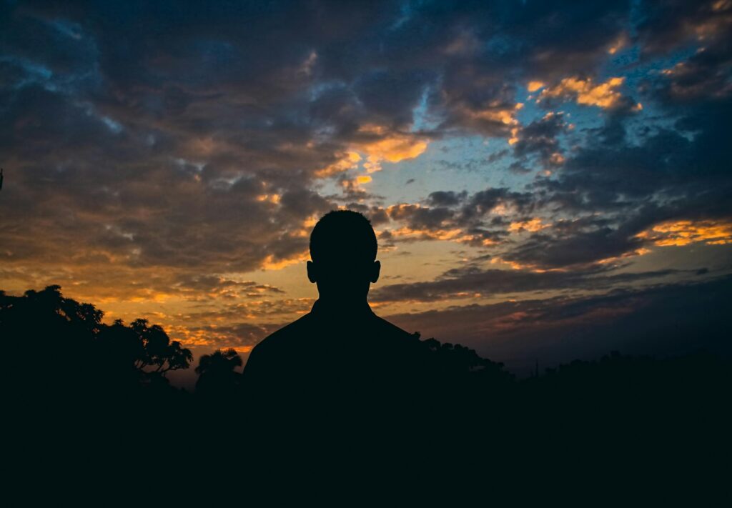 Man silhouetted against sunrise representing seizing windows of opportunity through faith and action.