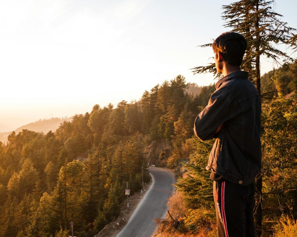 Man with unshakable destiny standing on a mountain ridge at sunrise symbolizing an unshakable destiny and a fresh start.